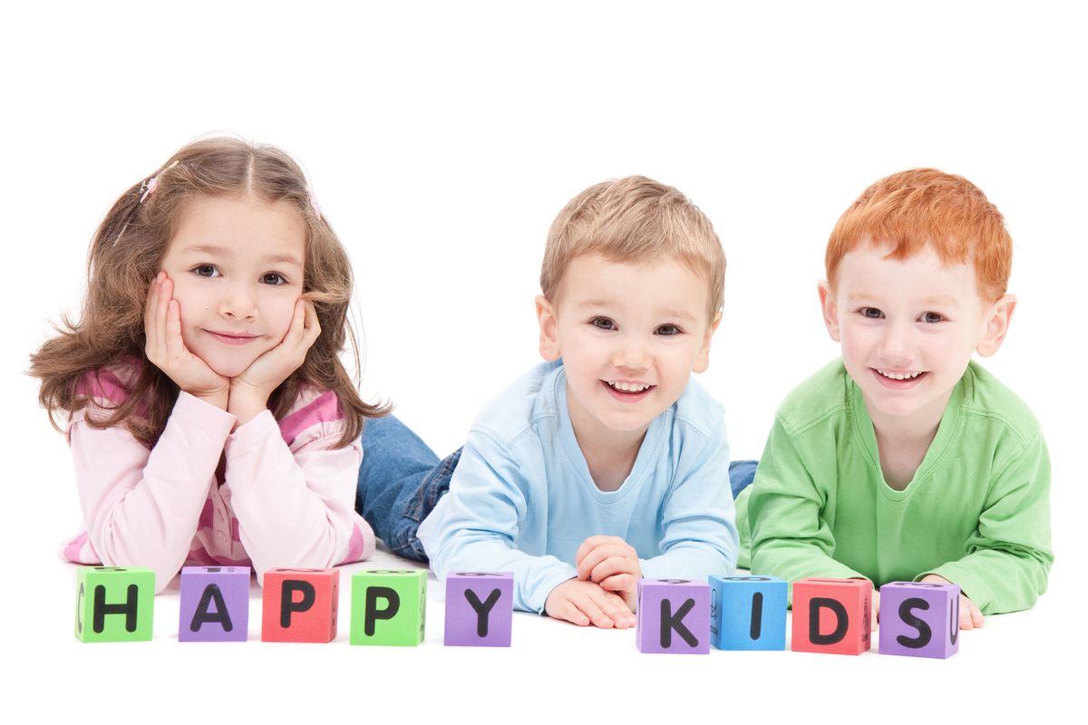 Three happy children with kids blocks. Isolated on white.